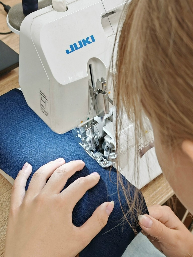 Работа на оверлоке JUKI: обработка края тёмно-синей ткани